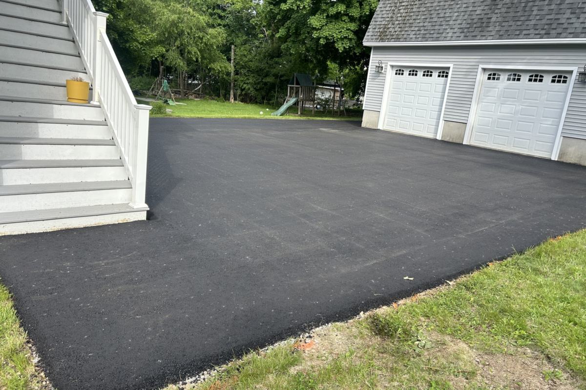 Freshly paved asphalt driveway in front of a two-car garage in Portland, Maine